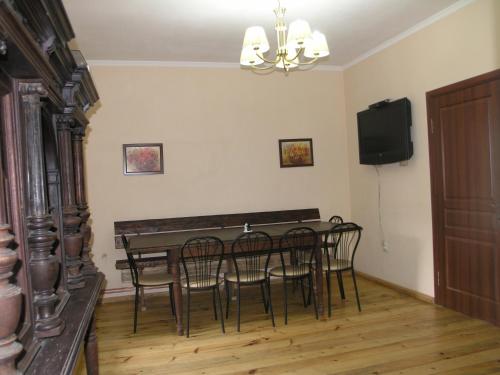 een eetkamer met een tafel en stoelen en een televisie bij Arnika Tatariv in Tatariv