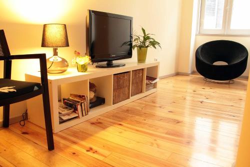 a living room with a television on a tv stand at OportoHouse in Porto