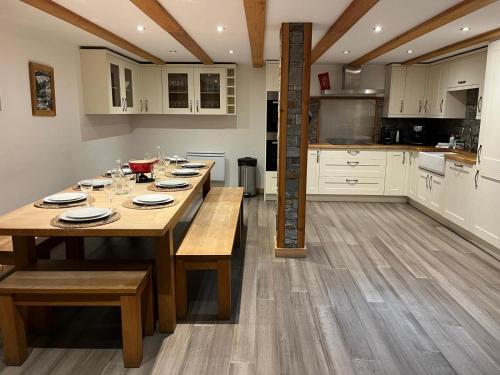 une cuisine avec une table en bois et des plaques de cuisson. dans l'établissement Chalet Chardonnet, à Chamonix-Mont-Blanc