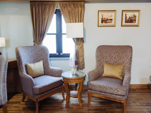 two chairs and a table in a room at Decharme Hotel in Chiang Mai