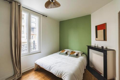 - une chambre avec un lit, une cheminée et une fenêtre dans l'établissement Élégance Moderne au Cœur de Reims place du forum, à Reims