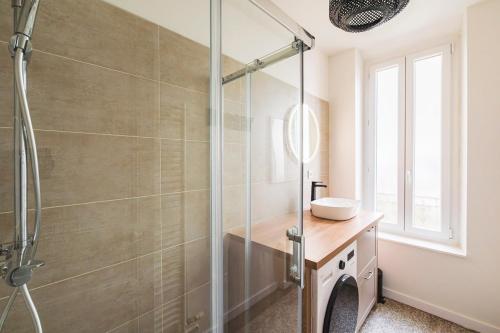 La salle de bains est pourvue d'une cabine de douche et d'un lavabo. dans l'établissement Élégance Moderne au Cœur de Reims place du forum, à Reims