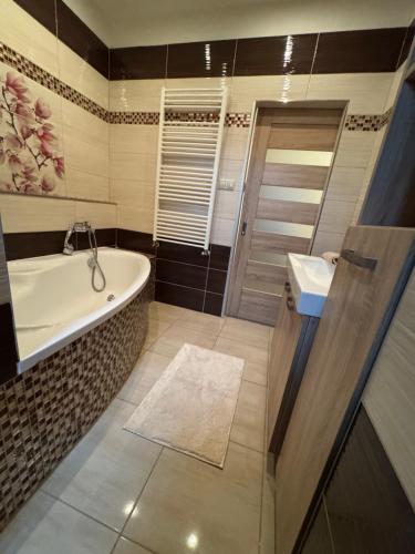 a bathroom with a tub and a sink at Apartmán Lupa 2 in Nové Zámky
