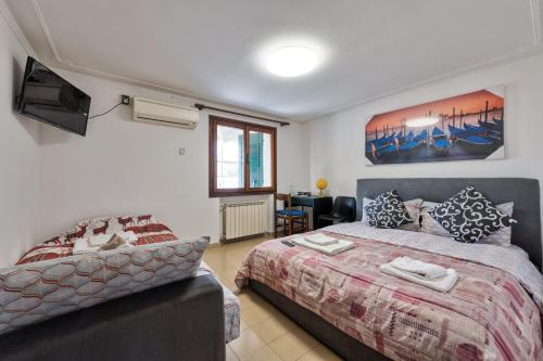 a bedroom with a bed and a couch at Villa Jolly Venezia - Mini Apartment in Venice