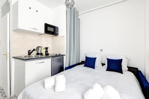 - une chambre avec un lit doté d'oreillers bleus et d'un lavabo dans l'établissement 5012 Suite Lauriston - Cosy Studio at Trocadero, à Paris