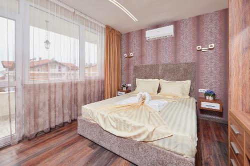 a bedroom with a large bed and a large window at Luxury Apartment Saint George Beauty and Style in Sveti Vlas