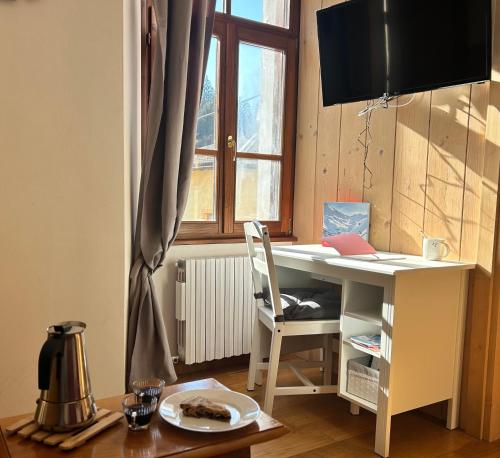 a desk with a chair next to a window at La Casetta Dei Sognatori in Valfurva