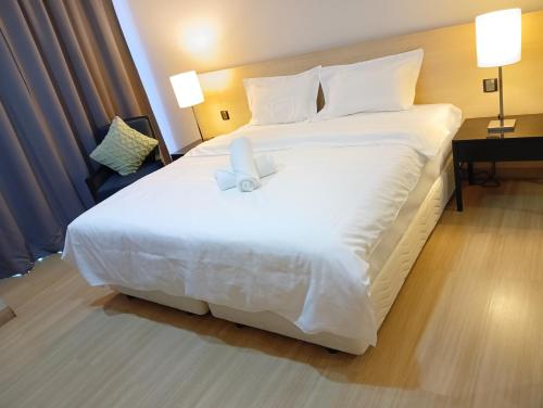 a large white bed in a hotel room at The Straits Suites by Ciconia in Melaka