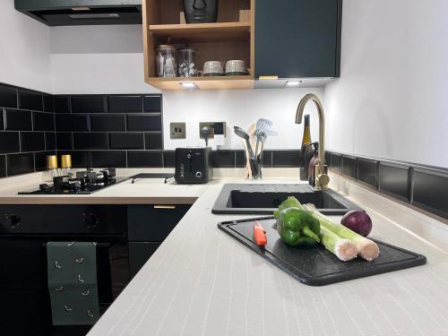 a kitchen counter with a tray of vegetables on a sink at Ground Floor Studio Apartment in Burnham on Crouch