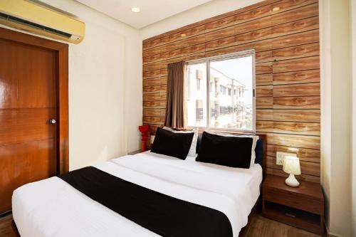 a bedroom with a bed with a wooden wall at Super Collection O Airport Road Formerly Hotel Kyra in Ahmedabad