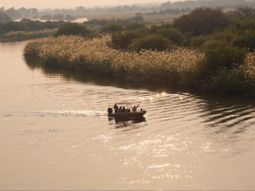 a group of people in a boat on a river at Kayova River Lodge in Ndiyona