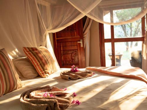 a bedroom with a bed with towels on it at Kayova River Lodge in Ndiyona