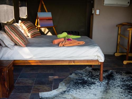 a bed with a pile of towels on it at Kayova River Lodge in Ndiyona