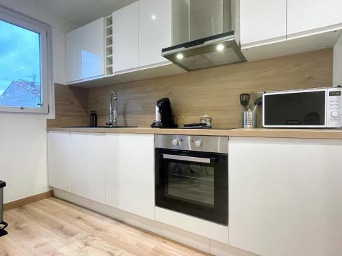 une cuisine avec une cuisinière et un micro-ondes dans l'établissement 2 min Rois de majorque, Netflix, air conditioning, à Perpignan