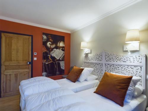 Cette chambre comprend 2 lits blancs et une porte. dans l'établissement Jolie maison pour 6 - Jacuzzi - proche de la mer, à Saint-Gilles-Croix-de-Vie