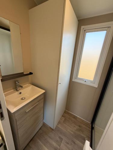 une salle de bain avec un lavabo et une fenêtre dans l'établissement Canet-en-Roussillon, à Canet
