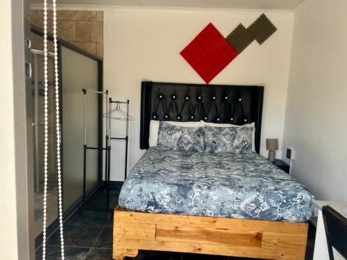a bedroom with a bed with a black head board at SapzRes at Klerksdorp in Klerksdorp