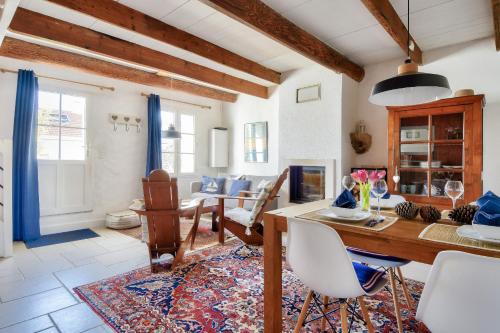 un salon avec une table et des chaises en bois dans l'établissement Maison pour 4 avec jardin et terrasse - 500m plage, à Barbâtre