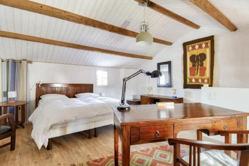 une chambre avec un lit et un bureau avec une lampe dans l'établissement Maison pour 4 avec jardin et terrasse - 500m plage, à Barbâtre