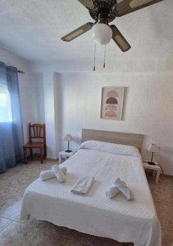 a bedroom with a white bed with a ceiling fan at 3ºA Escobar in Nerja