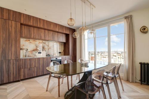 une salle à manger avec une table et des chaises en verre dans l'établissement Penthouse Eiffel view, à Boulogne-Billancourt