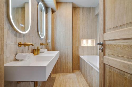 une salle de bain avec deux lavabos et un miroir dans l'établissement Penthouse Eiffel view, à Boulogne-Billancourt