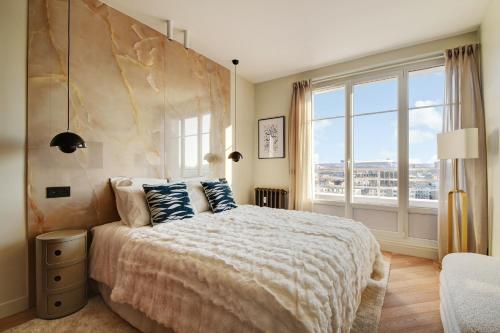 une chambre avec un grand lit avec une grande fenêtre dans l'établissement Penthouse Eiffel view, à Boulogne-Billancourt