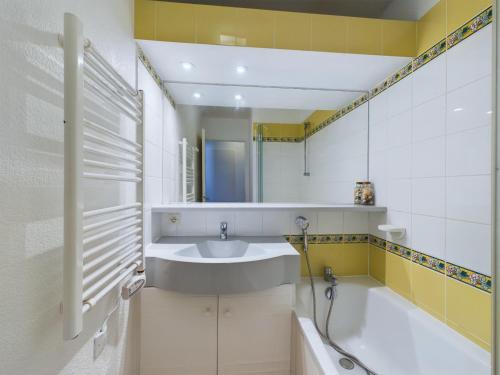 une salle de bain avec un lavabo et une baignoire dans l'établissement 450m de la plage, appartement en résidence pour 4, à La Baule-les-Pins