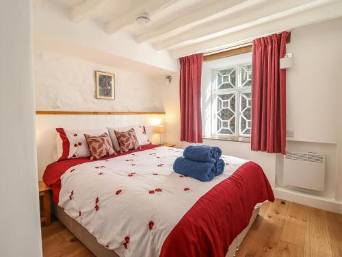 ein Schlafzimmer mit einem großen Bett mit einem blau ausgestopften Tier darauf in der Unterkunft Clywedog Cottage in Dolgellau