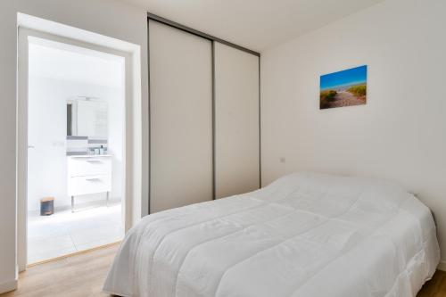 una camera da letto bianca con un letto grande e una finestra di Maison pour 8, 500m du port et des plages a Noirmoutier-en-l'lle