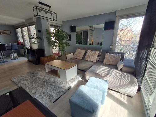 un salon avec un canapé et une table dans l'établissement Appartement T3 climatisé Lyon Caluire et Cuire, à Caluire-et-Cuire