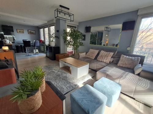 un salon avec un canapé et une table dans l'établissement Appartement T3 climatisé Lyon Caluire et Cuire, à Caluire-et-Cuire