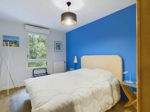 - une chambre bleue avec un grand lit et une fenêtre dans l'établissement Séjour à 4, Gare et Lajarrige, Grande terrasse, à La Baule-les-Pins