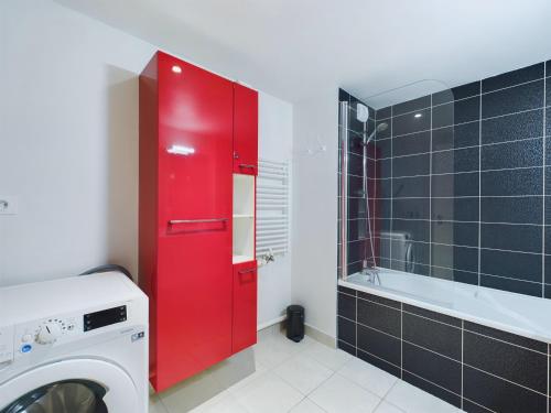 une armoire rouge dans une salle de bains avec lave-linge dans l'établissement Séjour à 4, Gare et Lajarrige, Grande terrasse, à La Baule-les-Pins