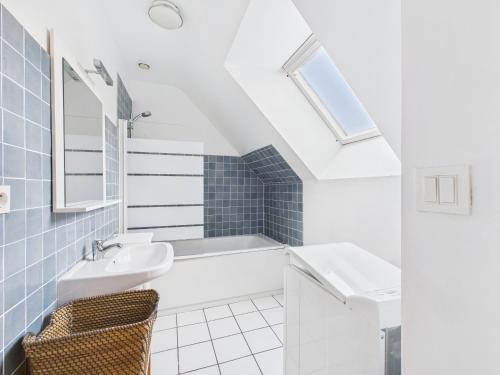 une salle de bain blanche avec un lavabo et une baignoire dans l'établissement Maison pour 6 en bord de mer - Jardin et piscine, à Pléneuf-Val-André