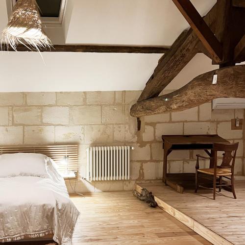 une chambre avec un lit et un bureau dans l'établissement Maisonnette - LA CLOCHETTE, à Lugon et l’Ile du Carney