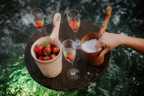 a table with a basket of strawberries and wine glasses at Chata za wsią - Czorsztyn Lake, Kluszkowce Ski in Kluszkowce