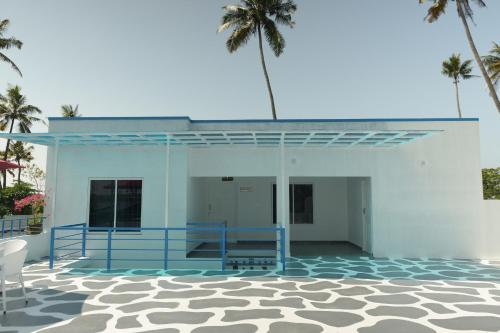 a blue and white building with palm trees in the background at Voitto Vista in Cochin