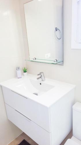 a bathroom with a white sink and a mirror at Casa lago jardin in Alicante