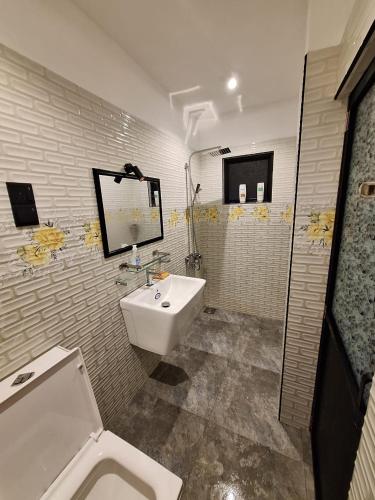a bathroom with a white sink and a toilet at Adrian Dilneth in Weligama