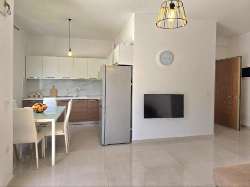 a kitchen with a refrigerator and a table with chairs at Perla Holiday Homes 246 in Lalzit Bay