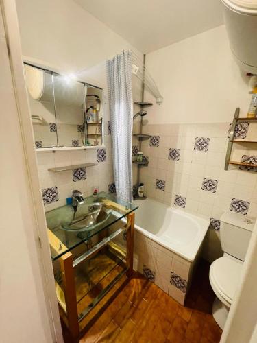 une salle de bain avec un lavabo, une baignoire et des toilettes dans l'établissement Clim Wifi Pkg privé PONANT, à La Grande Motte