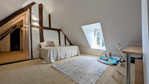 Cette chambre dispose d'une cheminée, d'une table et d'une chaise. dans l'établissement Maison au cœur du Perche, à Senonches