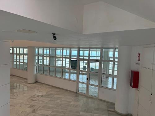 an empty room with glass doors and a large room with a building at Acogedor al lado de el mar in Roquetas de Mar