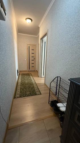 a room with a hallway with a door and a room with a rug at Милое уютное гнездышко in Almaty