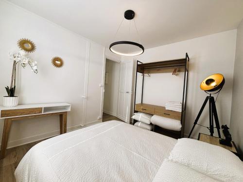 une chambre blanche avec un lit et un miroir dans l'établissement Résidence Carnot, à Bourges