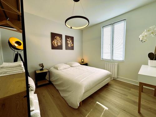 une chambre avec un lit blanc et une fenêtre dans l'établissement Résidence Carnot, à Bourges