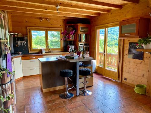 une cuisine avec un comptoir et deux tabourets de bar dans l'établissement Chalet de Meyje, à Habère-Lullin