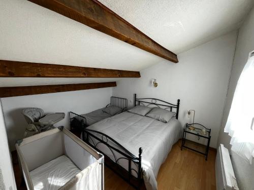 une chambre avec un lit noir et une fenêtre dans l'établissement Maison de vacances à la mer, à Port-la-Nouvelle