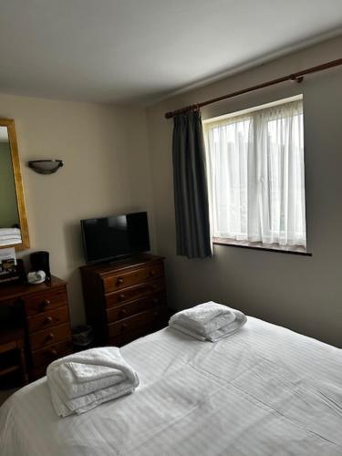 a bedroom with a bed with two towels on it at The Fountain Inn Tenbury Wells in Tenbury